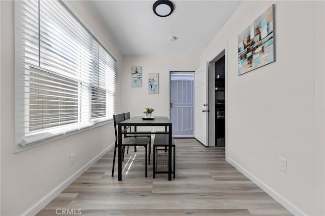 dining room featuring baseboards and light wood-type flooring