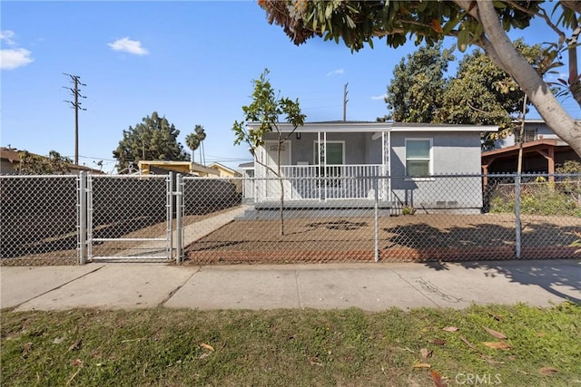 view of front of house with a fenced front yard, stucco siding, and a gate