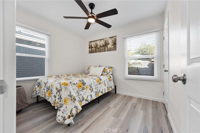 bedroom with a ceiling fan, baseboards, and wood finished floors