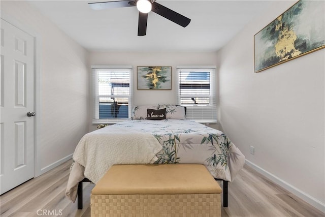 bedroom with light wood-type flooring, baseboards, and a ceiling fan