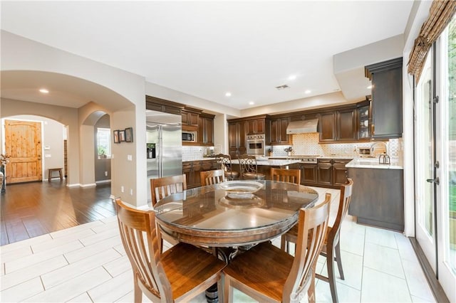 dining space with recessed lighting, baseboards, arched walkways, and visible vents