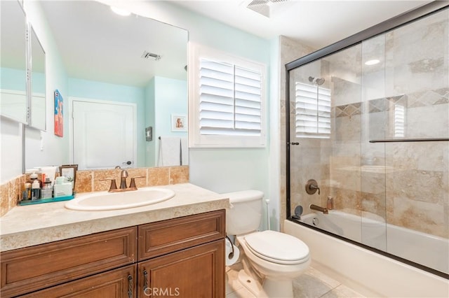 full bath with vanity, toilet, combined bath / shower with glass door, and visible vents