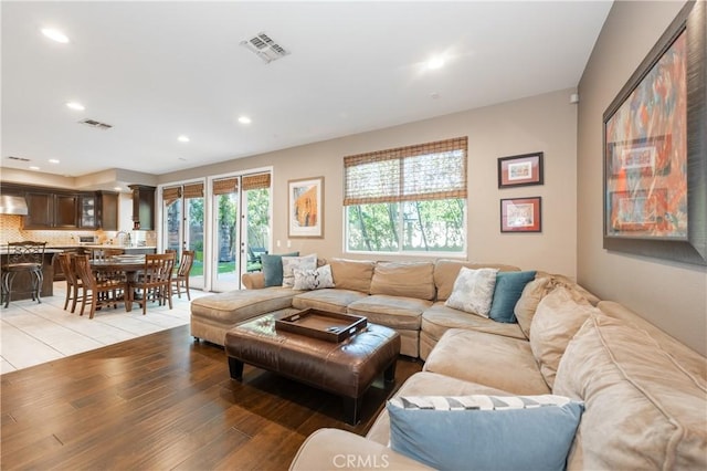 living room with recessed lighting, visible vents, and light wood-type flooring