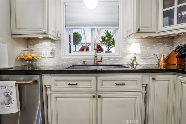 kitchen featuring dark countertops, decorative backsplash, white cabinets, and dishwasher
