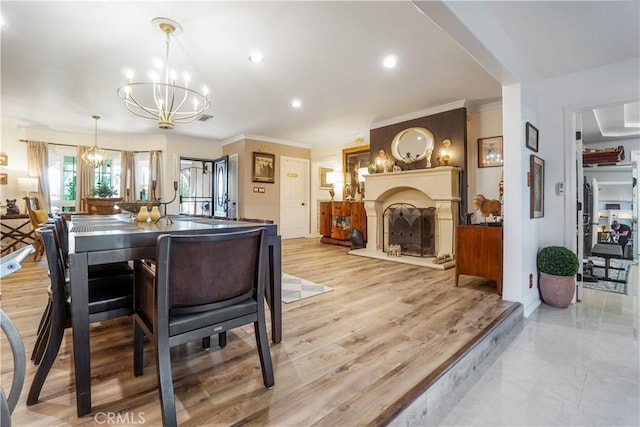 dining area featuring visible vents, a fireplace, recessed lighting, ornamental molding, and a notable chandelier