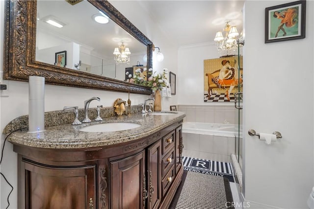 full bathroom with a bath, ornamental molding, an inviting chandelier, and a sink