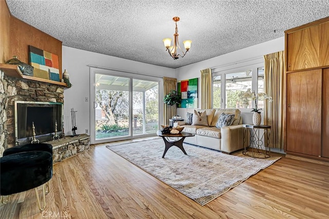 living area with a wealth of natural light, an inviting chandelier, and light wood finished floors