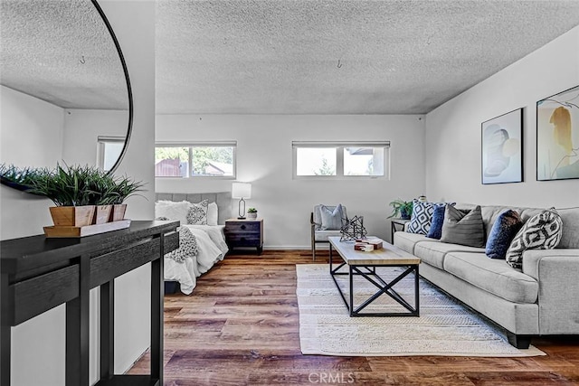 living area with wood finished floors, a healthy amount of sunlight, and a textured ceiling