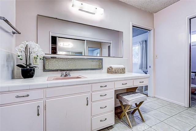 bathroom featuring tile patterned floors, backsplash, vanity, and a wall unit AC