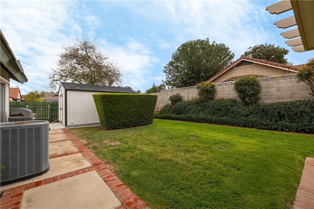 view of yard featuring a fenced backyard, a storage shed, central AC, and an outdoor structure