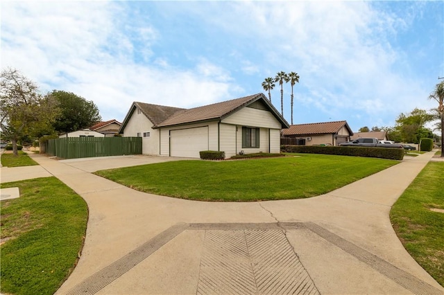 view of home's exterior with a lawn, an attached garage, driveway, and fence