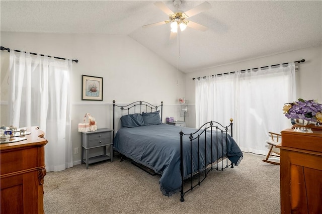 bedroom featuring vaulted ceiling, light colored carpet, and a textured ceiling