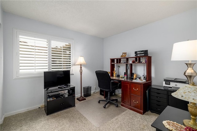 carpeted home office with a textured ceiling and baseboards