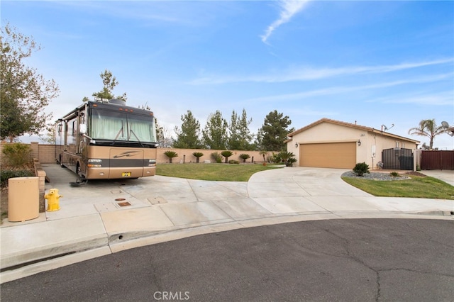 view of front of home featuring stucco siding, fence, concrete driveway, an attached garage, and a front yard