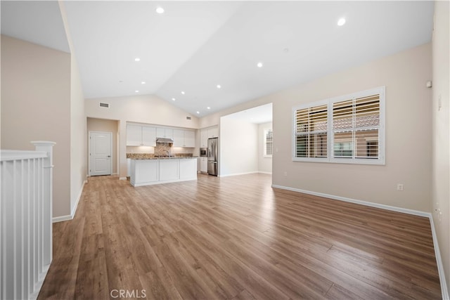 unfurnished living room with visible vents, baseboards, vaulted ceiling, recessed lighting, and light wood-style flooring