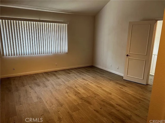 spare room featuring wood finished floors and baseboards