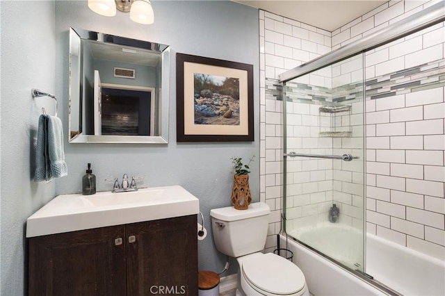 bathroom with combined bath / shower with glass door, visible vents, toilet, and vanity