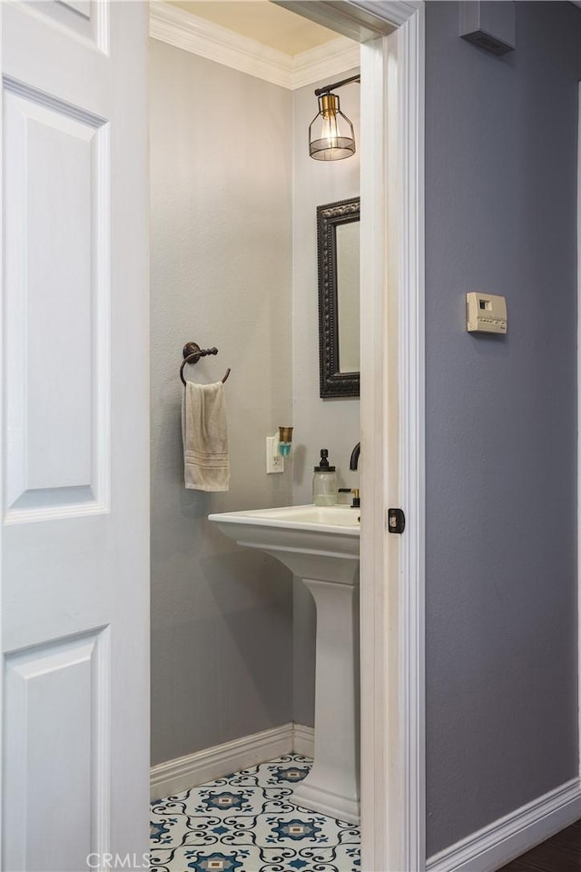 bathroom featuring tile patterned flooring, baseboards, and ornamental molding