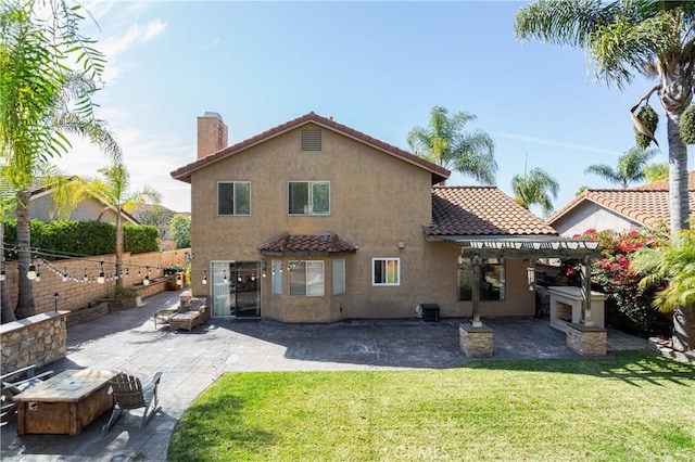 back of property featuring a tile roof, a yard, a patio area, and stucco siding