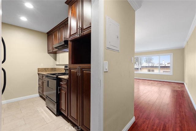 kitchen featuring under cabinet range hood, electric range, baseboards, and dark brown cabinetry