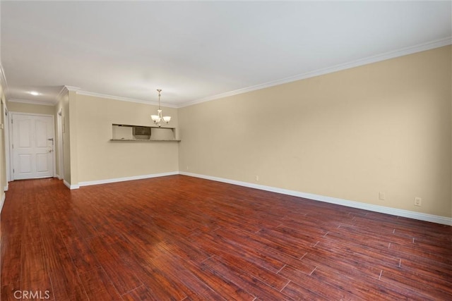 empty room with dark wood finished floors, a notable chandelier, crown molding, and baseboards