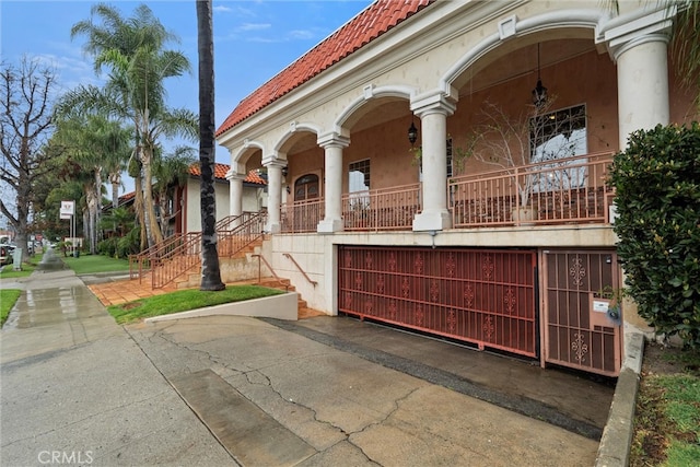 exterior space featuring stucco siding and a tiled roof