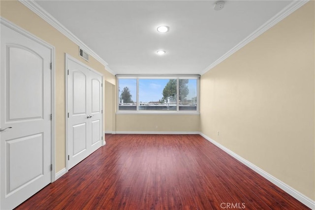 unfurnished bedroom with baseboards, wood finished floors, visible vents, and ornamental molding