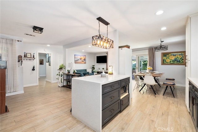 kitchen with light wood-style floors, pendant lighting, and light countertops