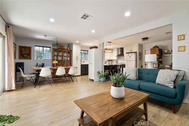 living area featuring recessed lighting, visible vents, and light wood finished floors