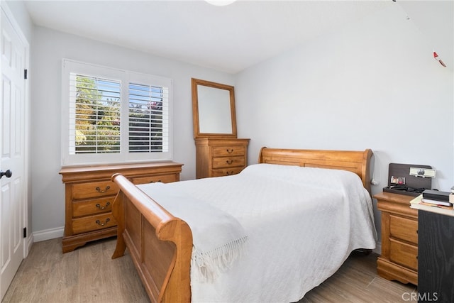 bedroom featuring baseboards and light wood-style floors