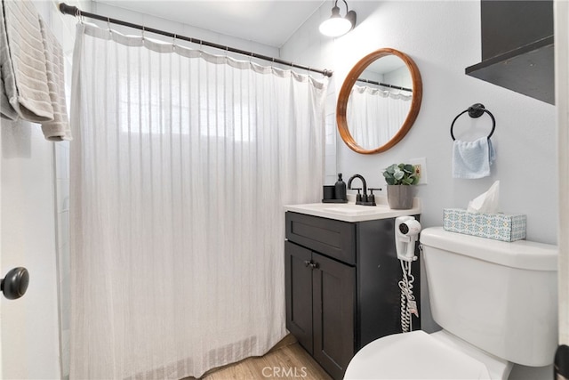 bathroom with a shower with shower curtain, toilet, vanity, and wood finished floors