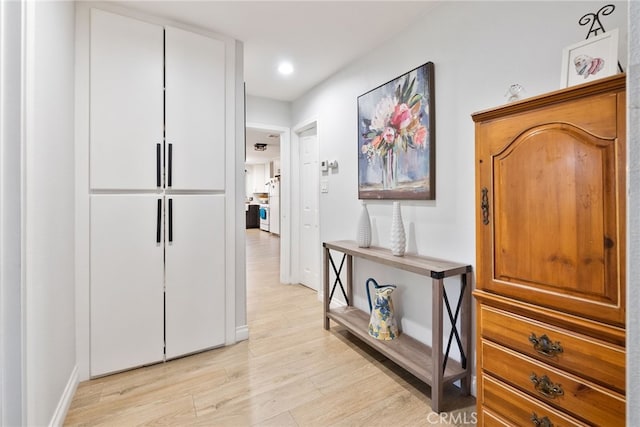 hallway with light wood finished floors, recessed lighting, and baseboards