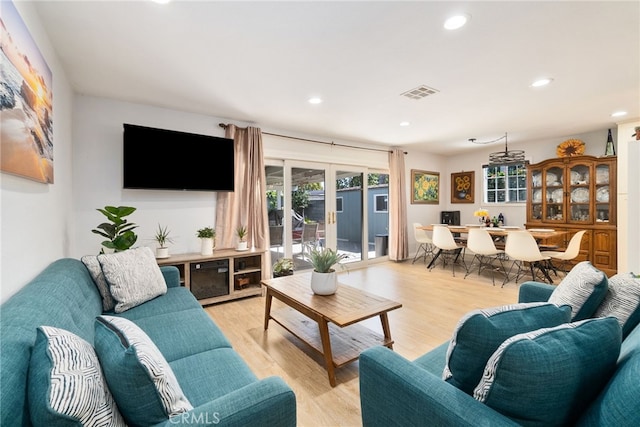 living area featuring recessed lighting, visible vents, french doors, and light wood finished floors