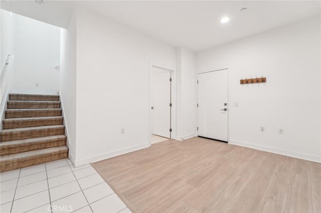 interior space featuring recessed lighting, light wood-type flooring, baseboards, and stairs