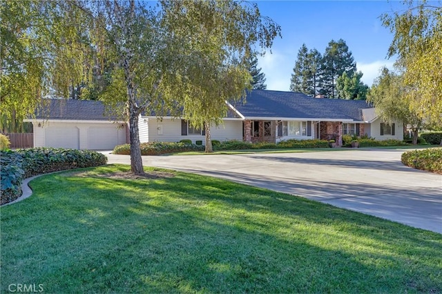 single story home featuring brick siding, a garage, a front yard, and driveway