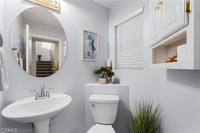 half bath featuring toilet and a sink