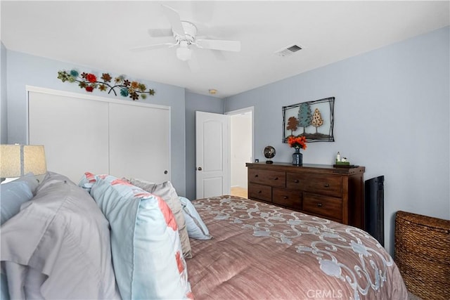bedroom with a closet, ceiling fan, and visible vents