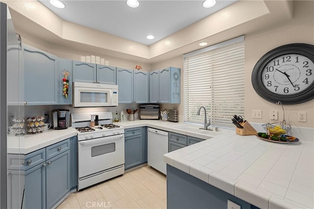 kitchen with tile counters, blue cabinets, recessed lighting, and white appliances