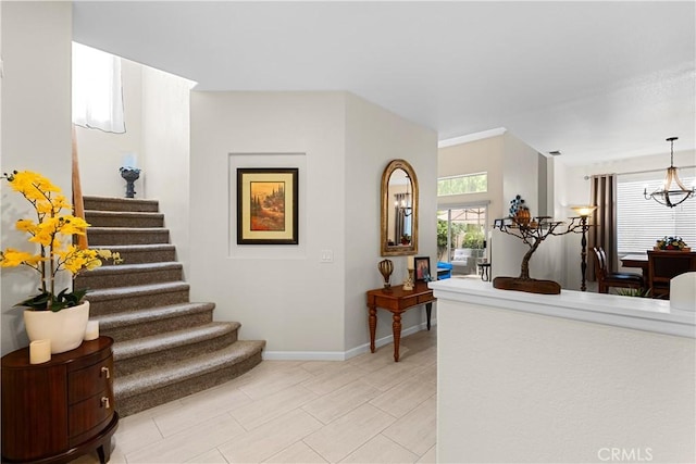 stairs with baseboards and an inviting chandelier