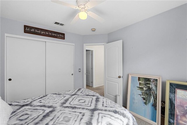 bedroom featuring a closet, carpet floors, visible vents, and a ceiling fan
