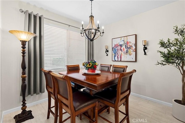 dining space featuring baseboards, an inviting chandelier, and plenty of natural light