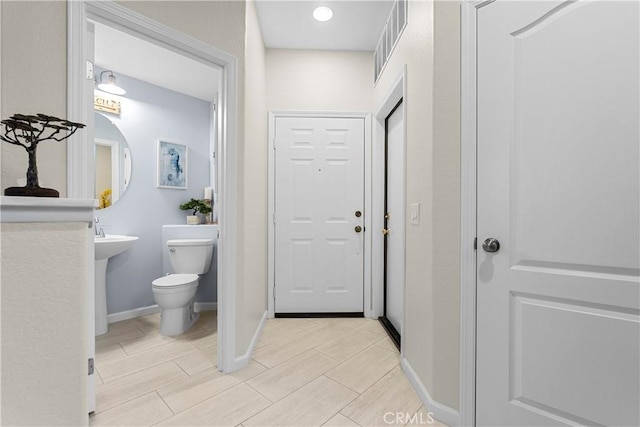 bathroom featuring toilet, baseboards, and visible vents