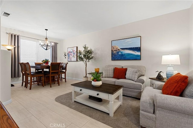 living room featuring light tile patterned flooring, baseboards, visible vents, and an inviting chandelier