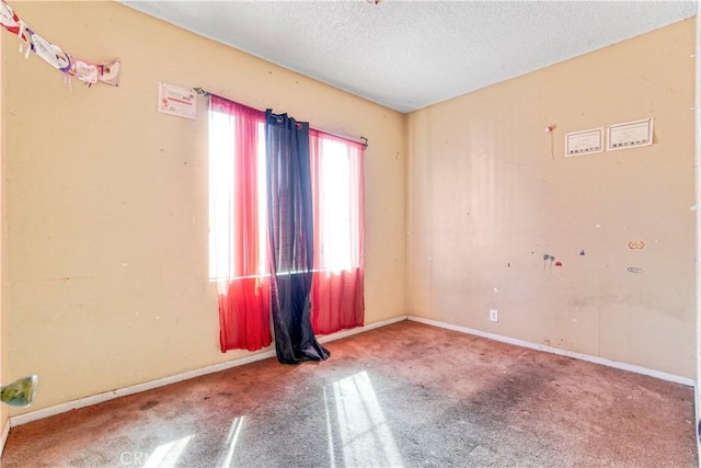 empty room with baseboards, a textured ceiling, and carpet