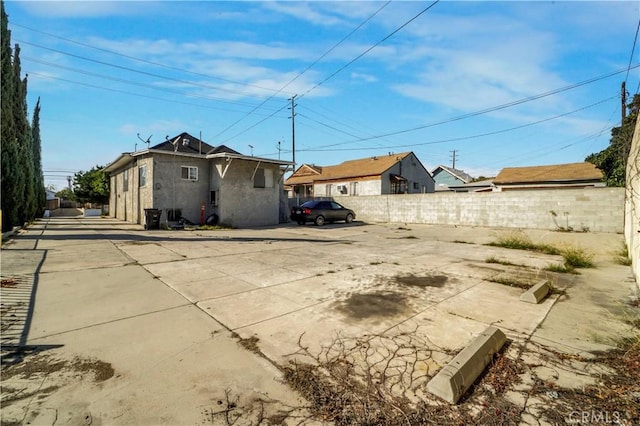 view of side of property with fence and stucco siding