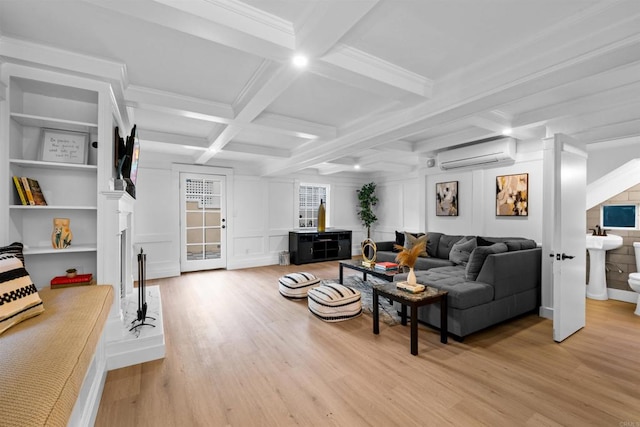 living area featuring beam ceiling, a decorative wall, light wood-style flooring, and an AC wall unit