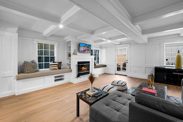 living room with beam ceiling, wood finished floors, and a decorative wall