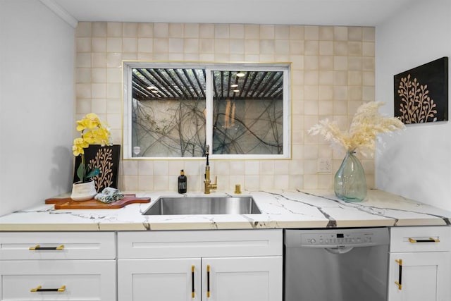 kitchen with stainless steel dishwasher, white cabinetry, backsplash, and a sink