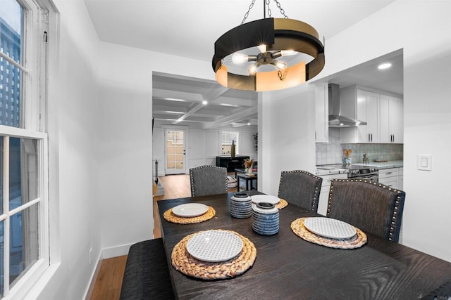 dining room with baseboards, beamed ceiling, an inviting chandelier, light wood-style floors, and coffered ceiling