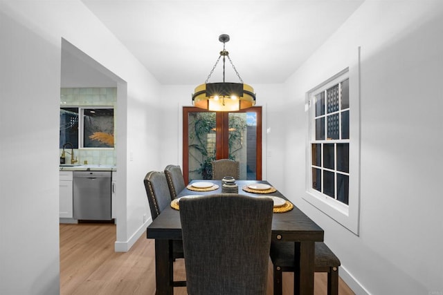 dining area featuring light wood finished floors and baseboards